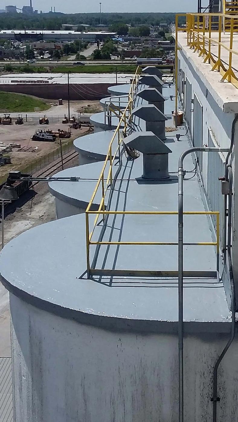 Polyurea-coated walkway and containment on top of a grain elevator